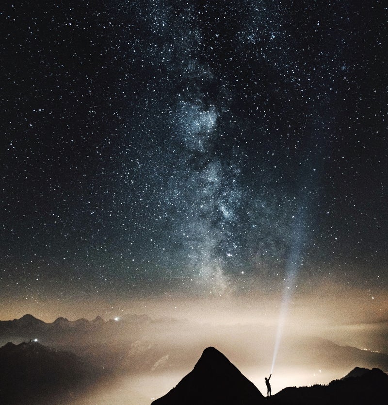A star-filled night sky above the mountains