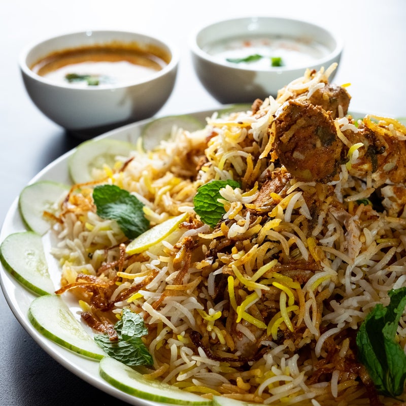 A plate of biryani served with side dishes